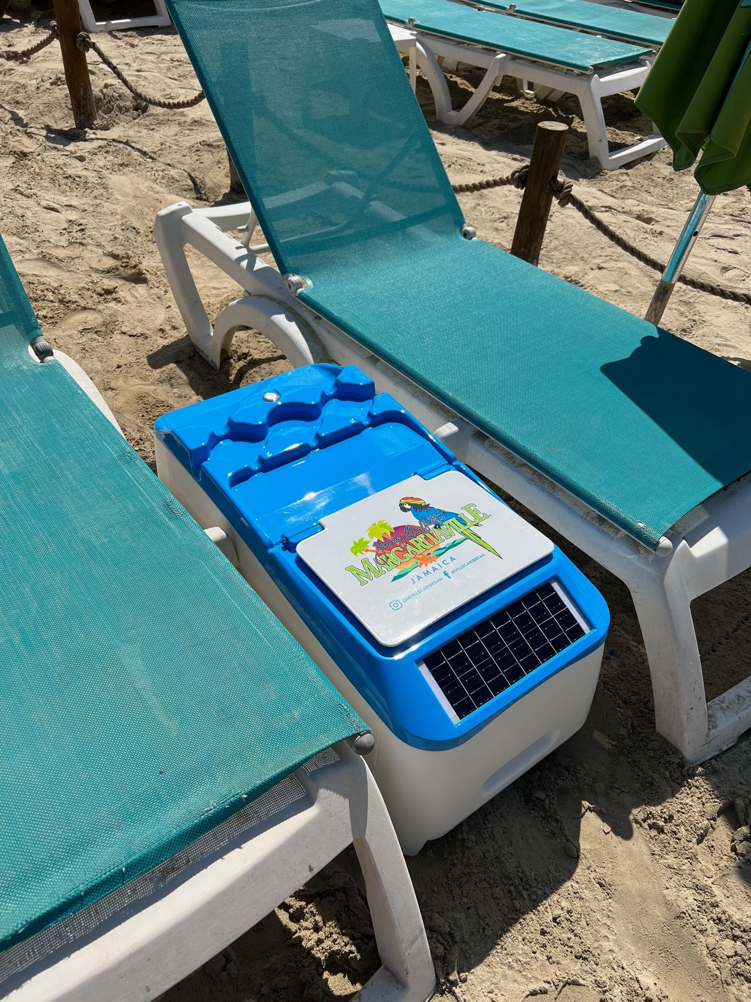 LounGenie solar-powered amenity unit deployed on private island beach beside cabana loungers